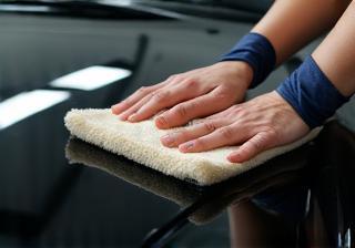 Technician applying polish on car hood
